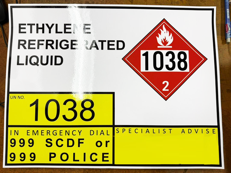 ISO tank truck hazmat label for Ethylene Refrigerated Liquid (UN No. 1038), showing a red flammable gas diamond placard with Class 2 designation. Emergency contact: dial 999 SCDF or 999 Police.